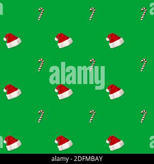 seamless pattern Santa hat and candy cane candy cane on green background Stock Photo