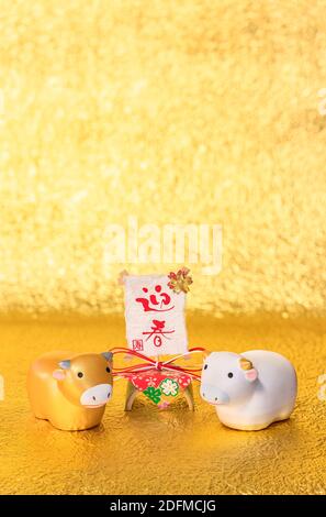 Japanese greeting Card with handwriting ideograms Geishun meaning Welcoming Spring and two cute Zodiacal animals figurines of cow for the Year of the Stock Photo