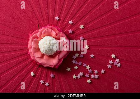 Coconut balls, ehite chocolate rafaello candies. Vegetarian round tasty dessert for romantic celebration on red background Stock Photo