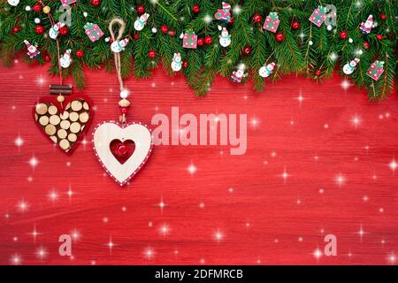 Red Christmas background. Christmas fir tree with decorative hearts on red wooden background, copy space. Stock Photo