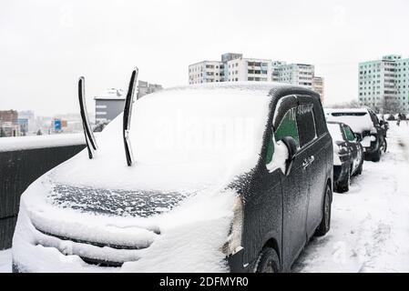 Car wipers covered with ice and snow after cold rain close up. Ice storm cyclone. City in winter. Snowy weather. Winter frosty scenes. Stock Photo