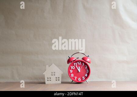 Miniature wooden house and black clock,Dream house,Real estate concept Stock Photo
