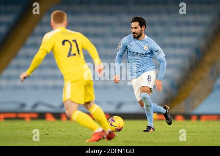 Manchester, UK. 6th Dec, 2020. Manchester City's Ilkay Gundogan (R) takes the ball downfield against Fulham's Harrison Reed during the Premier League match between Manchester City and Fulham in Manchester, Britain, on Dec. 5, 2020. Credit: Xinhua/Alamy Live News Stock Photo
