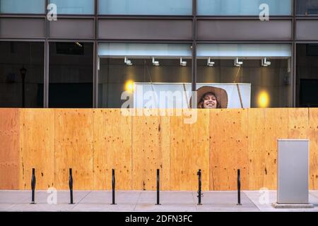 A woman in a shop advertisement smiles over boarded up windows, downtown Minneapolis, Minnesota, USA Stock Photo