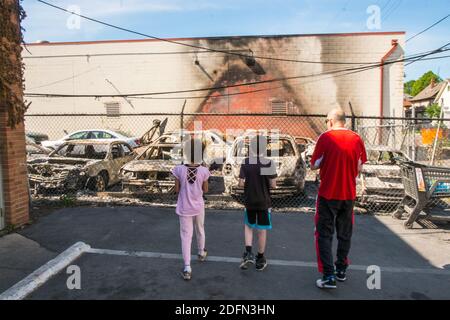 Children look at damage from the aftermath of the Minneapolis riots in June 2020