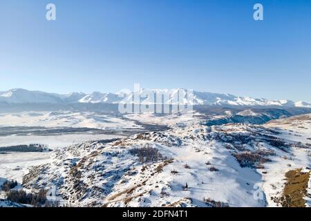 Early morning sunrise in steppes. Snow-covered pasture in the Altai Republic. The onset of winter, snow cover. Stock Photo