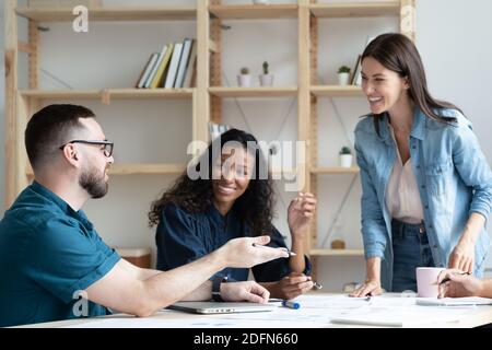 Smiling multiracial colleagues have fun working at meeting Stock Photo