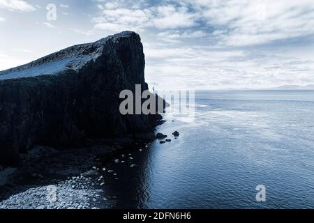 Rocky reef at the North Sea against the light, Neist Point peninsula with lighthouse, Dunvegan, Isle of Sky, Inner Hebrides, Scotland, Great Britain Stock Photo