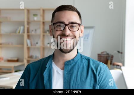Headshot portrait of smiling male employee in office Stock Photo