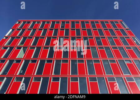 Capricorn office building, red facade, blue sky, Uniper headquarters, Media Harbour Duesseldorf, North Rhine-Westphalia, Germany Stock Photo