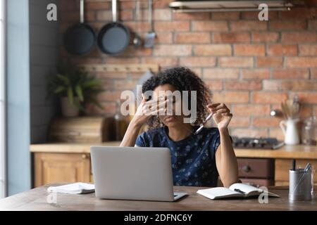 Unhappy young african american woman taking off eyeglasses, feeling tired. Stock Photo