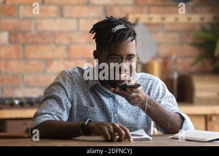 Happy biracial man sending mobile audio message. Stock Photo