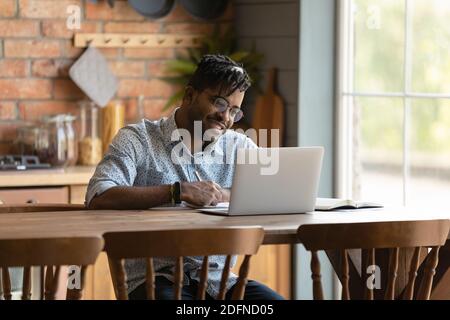 Happy young mixed race man enjoying learning distantly. Stock Photo