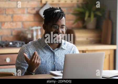 Handsome smiling young african ethnicity guy holding video call. Stock Photo