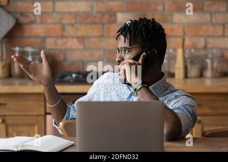 Focused young multiracial businessman holding cellphone conversation. Stock Photo