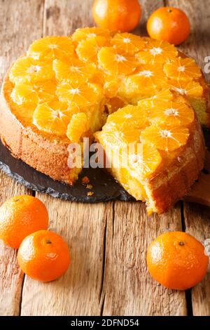 Sliced sponge tangerine pie close-up on a slate board on the table. vertical Stock Photo
