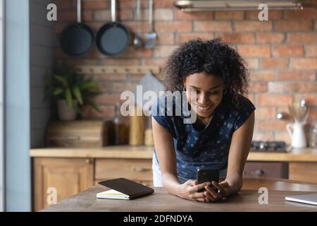 Addicted to technology young biracial lady using cellphone application. Stock Photo