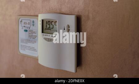 Digital Thermostat on the wall. Adjusting and setting thermostat to save energy Stock Photo