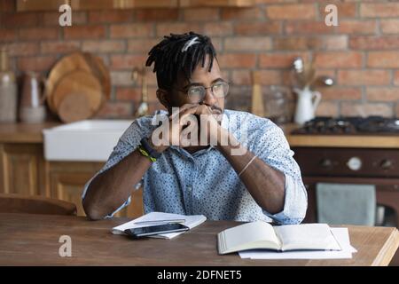 Thoughtful young african american man in glasses looking in distance. Stock Photo