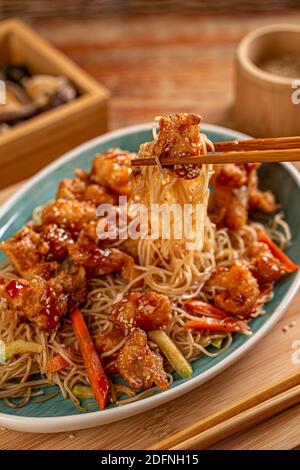 Spicy stir fried chicken on chopsticks, Chinese food Stock Photo