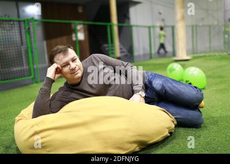 Man resting on bean bag chair indoor Stock Photo
