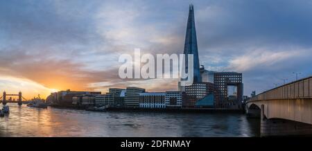 A panoramic sunrise view from London Bridge to Tower Bridge in London.