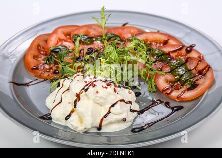 Strachatella cheese with tomato, balsamico and rucola Stock Photo