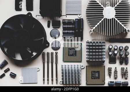 Computer and laptop hardware - CPU, fan cooler, battery, capacitors, radiator, chip on the white background with copy space, flat lay. PC parts top view. Repair, assembly, engineering concept Stock Photo