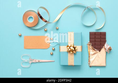 Christmas gift boxes wrapped in gold with baubles, and wrapping accessories Stock Photo
