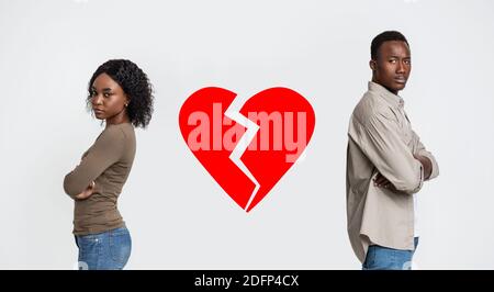 Disappointed black man and woman with broken heart between them Stock Photo