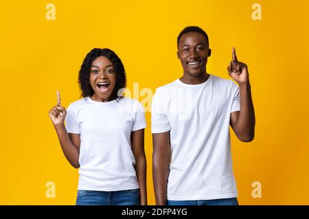 Inspired black man and woman pointing fingers up Stock Photo