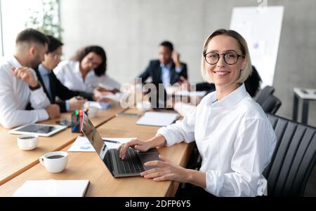 Young Businesswoman Sitting At Laptop Having Corporate Meeting In Office Stock Photo