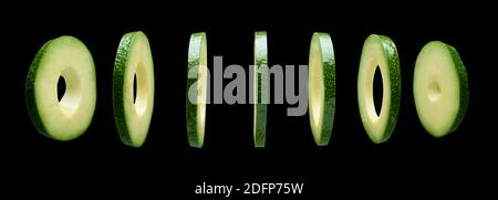 Avocado slices levitating in the air on black background Stock Photo