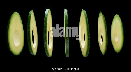 Avocado slices levitating in the air on black background Stock Photo