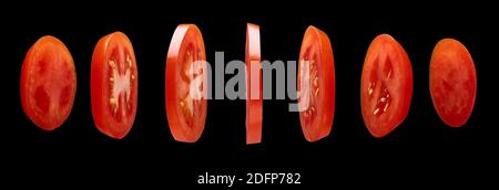 Red Tomato slices levitating in the air on black background Stock Photo