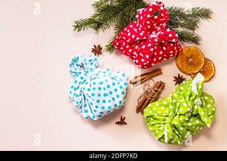 Japanese traditional gift wrapping, zero waste furoshiki on pink background. Flat lay top view. Stock Photo