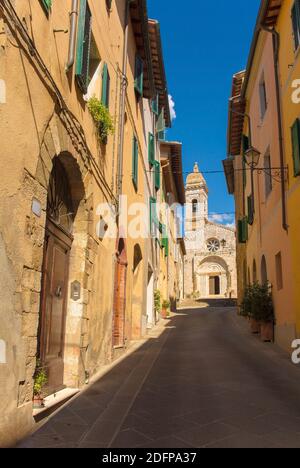 A residential road leads to the Collegiata dei Santi Quirico e Giulitta in the historic medieval village of San Quirico D'Orcia, Siena Province, Tusca Stock Photo