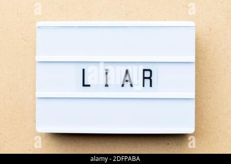 White lightbox with word liar on wood background Stock Photo