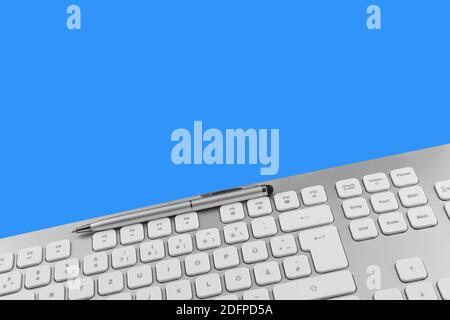 PC keyboard and pen against blue background Stock Photo