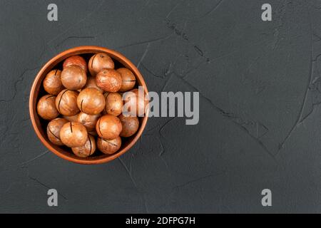 Macadamia nuts in a bowl on an empty concrete background Stock Photo
