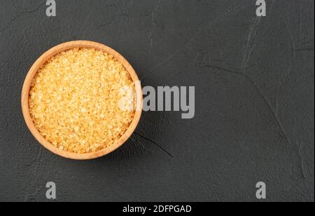 Wooden bowl with brown sugar on an empty concrete background, top view Stock Photo