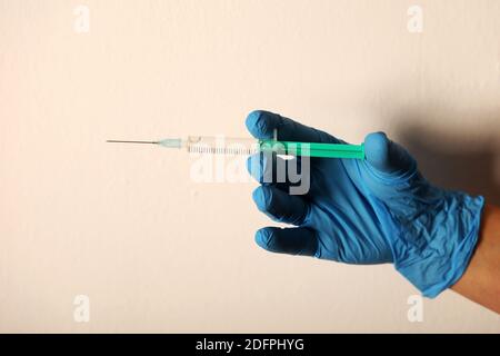 The doctor in blue gloves holds a syringe with vaccine Stock Photo