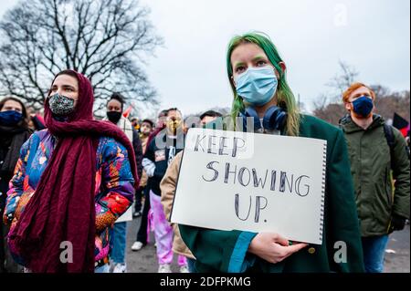 A protester wearing face mask holds a placard during the demonstration.Several organizations and groups organized a demonstration against racism and inequality. For years, peaceful protests against the racist caricature 'Black Pete' have been the target of extreme far-right groups and racist intimidation. Hundreds of people gathered to condemn racist police violence, ethnic profiling, and discrimination in all aspects of human life. Stock Photo