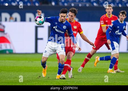 Gelsenkirchen, Germany. 06th Dec, 2020. Football: Bundesliga, FC Schalke 04 - Bayer Leverkusen, 10th matchday at the Veltins Arena. Schalke's Suat Serdar (l) and Leverkusen's Julian Baumgartlinger fight for the ball. Credit: Guido Kirchner/dpa - IMPORTANT NOTE: In accordance with the regulations of the DFL Deutsche Fußball Liga and the DFB Deutscher Fußball-Bund, it is prohibited to exploit or have exploited in the stadium and/or from the game taken photographs in the form of sequence images and/or video-like photo series./dpa/Alamy Live News Stock Photo