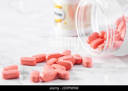 Pink medical pills of Caltrate with a transparent bottle isolated on a white background Stock Photo