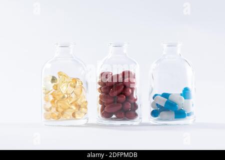 A closeup shot of different medical pills in transparent bottles isolated on a white background Stock Photo