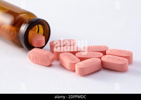 pink medical pills of Caltrate with a transparent bottle isolated on a white background Stock Photo