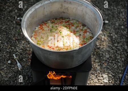 Cooking soup in cast iron boiler on burning campfire. Pot with soup over  the open fire outdoors. Tourism in Latvia. Cooking soup in a pot on  campfire Stock Photo - Alamy