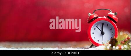 Vintage clock approaching midnight against red Christmas background with large copy space. New Year holidays banner with large space for text Stock Photo