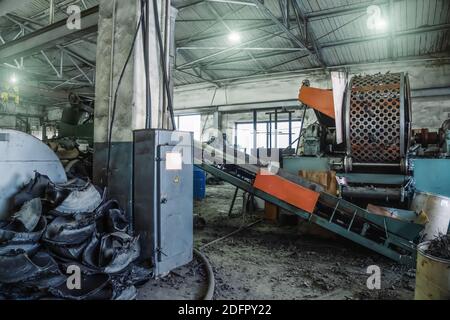 Rubber recycling processing factory on special industrial equipment and conveyor line with cut used car tires. Recycling waste, saving environment from pollution. Stock Photo